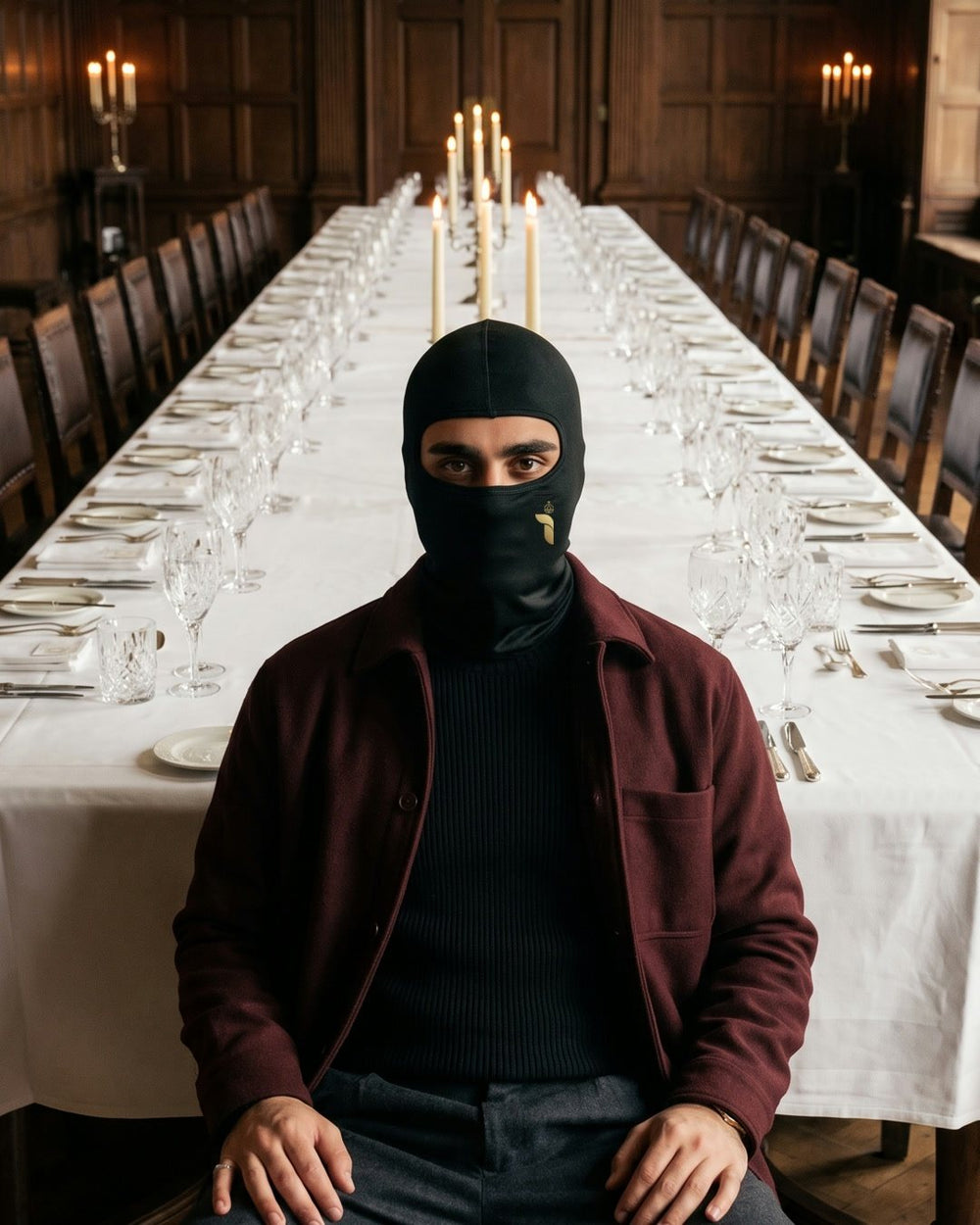 Maskierte Figur als einziger Gast an einer langen Tafel